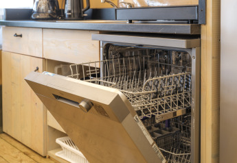 Open dishwasher in the kitchen of a safari tent at Rhederlaagse Meren recreation park in the Netherlands.