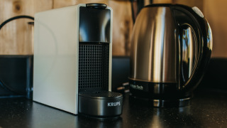 Een foto van een koffiemachine en waterkoker op een aanrecht in een safaritent op Camping Lucherino, Italië.