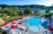 Swimmingpool med røde parasoller og liggestole på Flower Camping L'Ile d'Offard i Pays de la Loire, Frankrig.