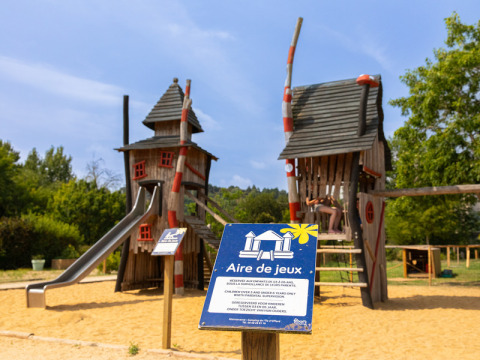Spielplatz mit märchenhaften Holzhäusern und Rutsche im Flower Camping L'Ile d'Offard, Pays de la Loire, Frankreich.
