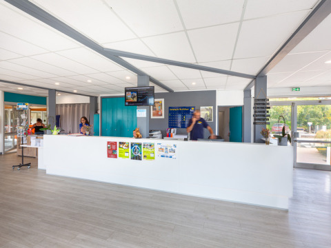 Receptionen hos Flower Camping L'Ile d'Offard i Pays de la Loire, Frankrig, med personale bag skranken.