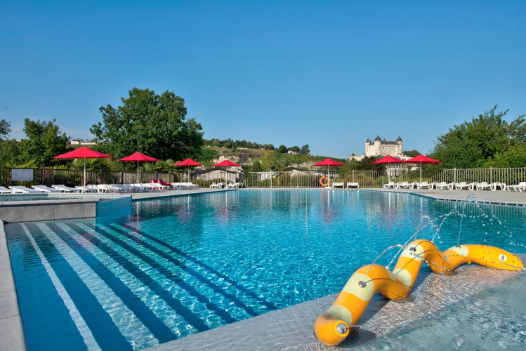 Outdoor pool with yellow water slide and red umbrellas at Flower Camping L'Ile d'Offard in Pays de la Loire, France.