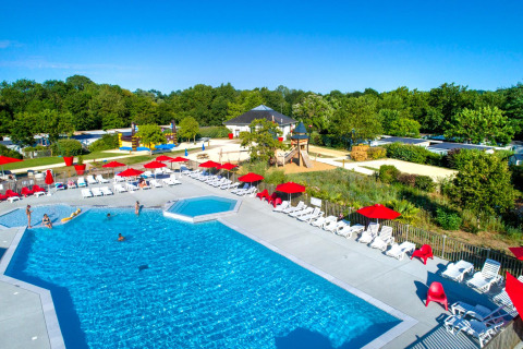 Piscine extérieure avec transats et parasols rouges au Flower Camping L'Ile d'Offard, Pays de la Loire, France.