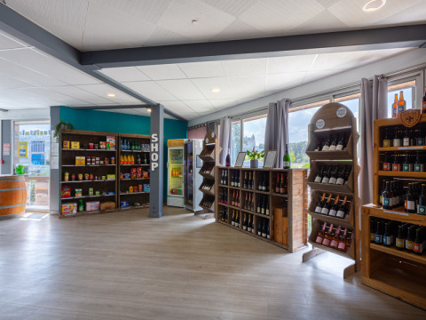 Innenansicht des Shops bei Flower Camping L'Ile d'Offard mit Weinregalen und Lebensmitteln in Frankreich.