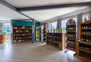 Innenansicht des Shops bei Flower Camping L'Ile d'Offard mit Weinregalen und Lebensmitteln in Frankreich.