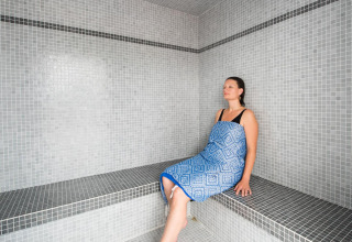 Woman relaxing in a steam room at Flower Camping L'Ile d'Offard, a holiday park in Pays de la Loire, France.