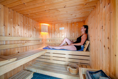Vrouw ontspant in een houten sauna bij Flower Camping L'Ile d'Offard in Pays de la Loire, Frankrijk.