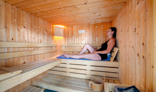 Vrouw ontspant in een houten sauna bij Flower Camping L'Ile d'Offard in Pays de la Loire, Frankrijk.