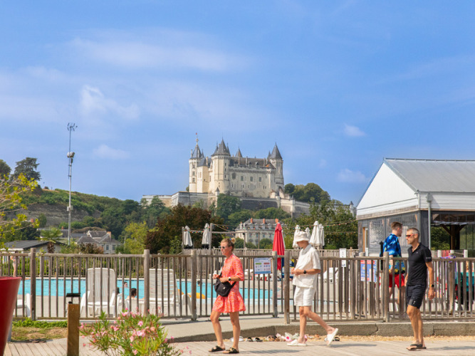 Parque vacacional Flower Camping L'Ile d'Offard con piscina y vista al castillo de Saumur en Pays de la Loire, Francia.