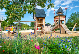 Spielplatz mit lustigen Holztürmen und blühender Wiese bei Flower Camping L'Ile d'Offard in Pays de la Loire, Frankreich.
