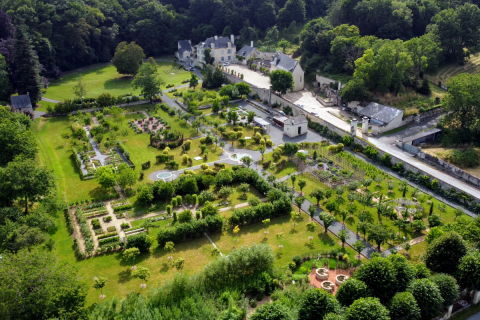 Aerial view of a formal garden and estate near Saumur, France, surrounded by lush forests and greenery.