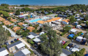 Aerial view of Flower Camping Les Ilates with pool, cabins and sea in Nouvelle-Aquitaine, France.