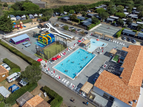 Vue aérienne du Flower Camping Les Ilates en Nouvelle-Aquitaine, France, avec piscine et toboggans.
