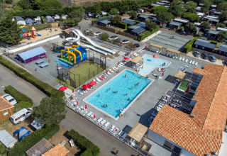 Luchtbeeld van Flower Camping Les Ilates vakantiepark in Nouvelle-Aquitaine met zwembad en glijbanen.