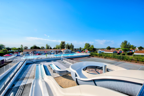 Area piscina all'aperto con scivoli d'acqua e lettini al Flower Camping Les Ilates in Nouvelle-Aquitania, Francia.