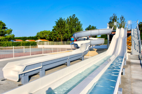 White water slides at Flower Camping Les Ilates, a holiday park in Nouvelle-Aquitaine, France, on a sunny day.