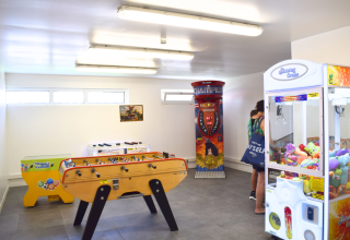 Spielzimmer im Flower Camping Les Ilates mit Kicker, Boxmaschine und Greifautomaten mit Plüschtieren.