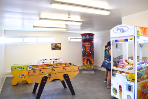 Spielzimmer im Flower Camping Les Ilates mit Kicker, Boxmaschine und Greifautomaten mit Plüschtieren.