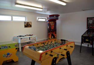 Sala giochi con calciobalilla, giochi arcade e punching ball a Flower Camping Les Ilates, Nouvelle-Aquitaine.