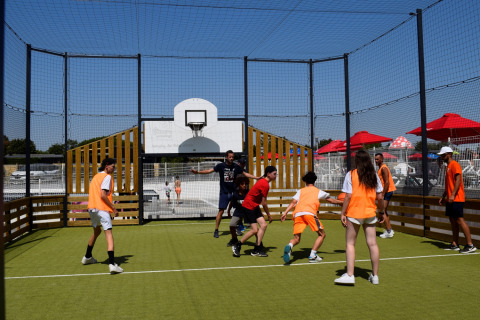 Personas juegan a la pelota en una cancha exterior en Flower Camping Les Ilates, Nueva Aquitania, Francia.