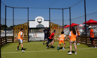 Mensen spelen balspel op een buitenveld bij Flower Camping Les Ilates in Nouvelle-Aquitaine, Frankrijk.