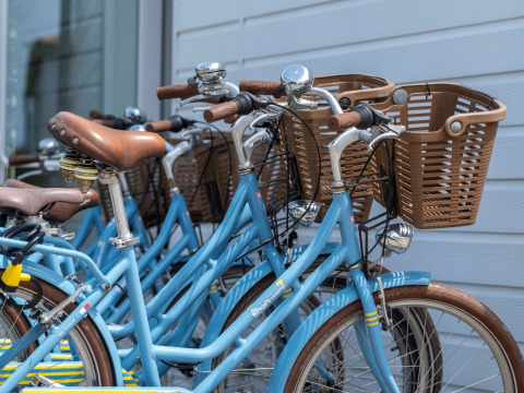 Bicicletas azules con cestas aparcadas junto a una pared, foto tomada en Flower Camping Les Ilates en Francia.