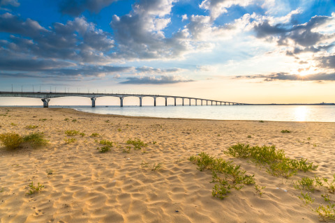 Ponte visto dalla spiaggia sabbiosa a Flower Camping Les Ilates, Nouvelle-Aquitaine, Francia, al tramonto.