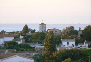 Vista di un villaggio costiero con case dai tetti rossi e alberi a Flower Camping Les Ilates, Nouvelle-Aquitaine.
