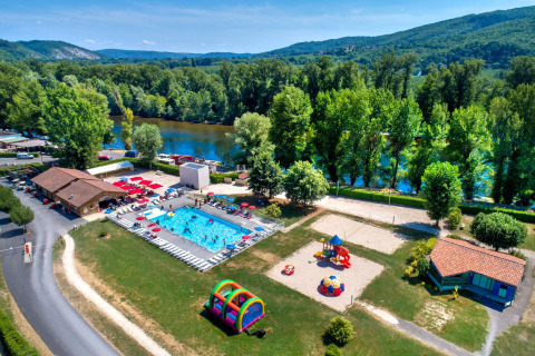 Luchtfoto van Flower Camping Les Ondines in Occitanië, Frankrijk, met zwembad, speeltuin en rivierlandschap.