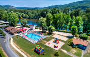 Vista aerea di Flower Camping Les Ondines in Occitania, Francia, con piscina, parco giochi e paesaggio fluviale.