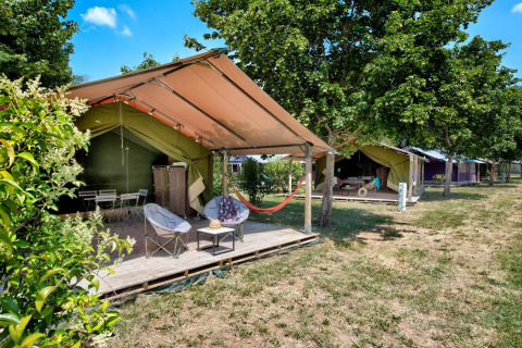Safari tents with outdoor seating areas at Flower Camping Les Ondines, a holiday park in Occitanie, France.