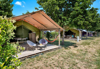 Safari tents with outdoor seating areas at Flower Camping Les Ondines, a holiday park in Occitanie, France.