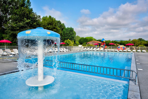Buitenzwembad met kinderbadje, waterpaddenstoel en ligstoelen bij Flower Camping Les Ondines, Occitanië, Frankrijk.