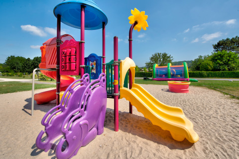 Parque infantil colorido con toboganes y juegos en Flower Camping Les Ondines, Occitanie, Francia.