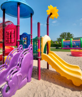 Colorful playground with slides and climbing frames at Flower Camping Les Ondines in Occitanie, France.