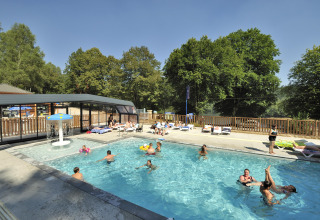 Outdoor swimming pool with people relaxing and playing at Flower Camping La Plage, Nouvelle-Aquitaine, France.