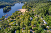 Aerial view of Flower Camping La Plage holiday park in Nouvelle-Aquitaine, France, with beach and lake.