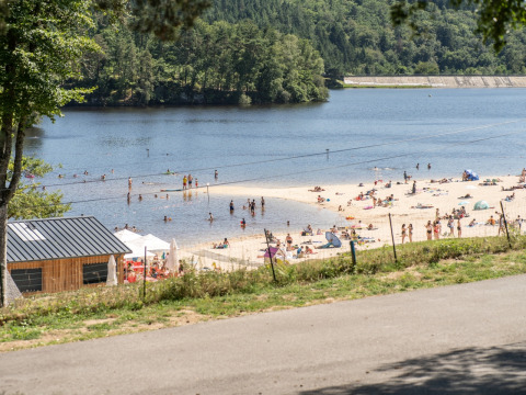 Strand en mensen aan het zwemmen bij Flower Camping La Plage in Nouvelle-Aquitaine, Frankrijk, met bomen.