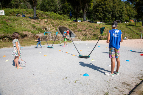Kinderen en volwassenen spelen badminton buiten aan Flower Camping La Plage, Nouvelle-Aquitaine, Frankrijk.