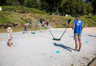 Bambini e adulti giocano a badminton all'aperto al Flower Camping La Plage, Nouvelle-Aquitaine, Francia.