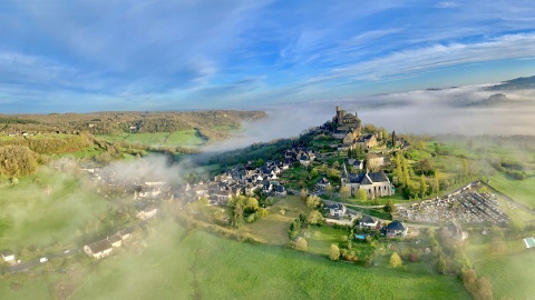 Aerial view of Flower Camping La Plage in Nouvelle-Aquitaine, France, featuring green fields and morning mist.