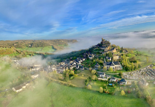 Vue aérienne de Flower Camping La Plage en Nouvelle-Aquitaine, France, avec champs verts et brume du matin.