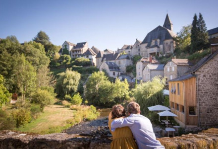 Par nyder udsigten over den charmerende landsby Treignac-sur-Vézère, omkranset af grønne bakker.