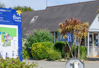 Indgang til Flower Camping Cap Finistère feriepark i Bretagne, Frankrig med blå skilt og reception.