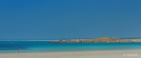 Strand bei Flower Camping Cap Finistère in der Bretagne, Frankreich, mit klarem Wasser und blauem Himmel.