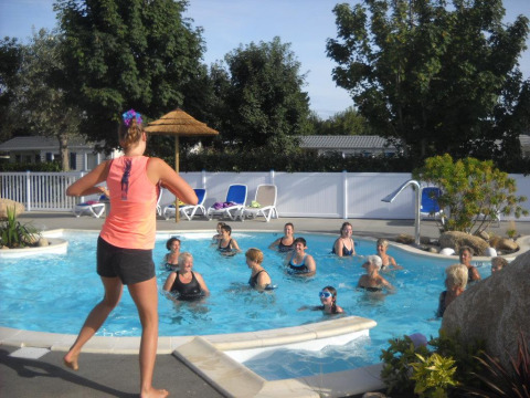 Un gruppo di persone partecipa a ginnastica in acqua in una piscina all’aperto in un campeggio in Bretagna.