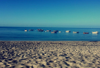 Plage de sable et bateaux flottant près de Flower Camping Cap Finistère, en Bretagne, France.