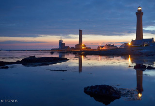 Evening view of lighthouses and buildings by the water at Flower Camping Cap Finistère in Brittany, France.