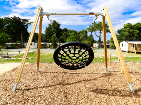 Columpio de red en el parque infantil de Flower Camping Le Vieux Moulin, un camping en Bretaña, Francia.