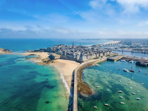 Luftaufnahme von Flower Camping Le Vieux Moulin Ferienpark mit Strand und Altstadt in der Bretagne, Frankreich.